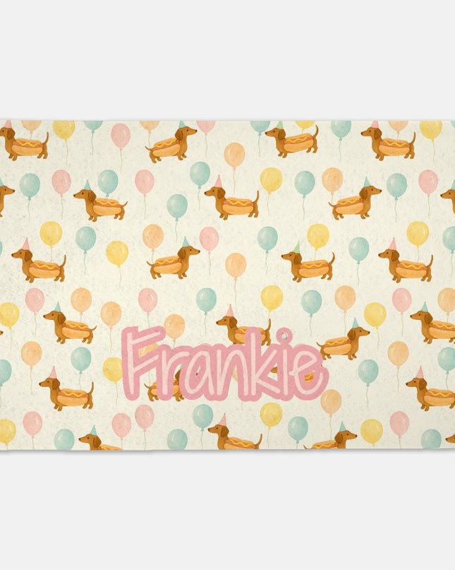 Placemat with dachshund pattern and 'Frankie' text on a white background