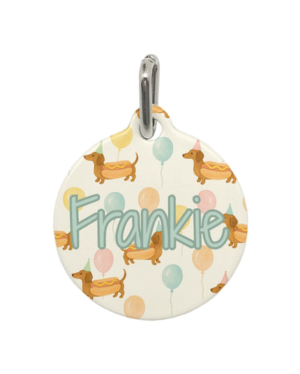 Round pet tag with 'Frankie' and dog illustrations on a white background