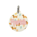 Round pet tag with 'Frankie' and dog illustrations on a white background