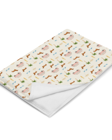 Coastal dachshund blanket draped over chair in lifestyle photo with surf van print
