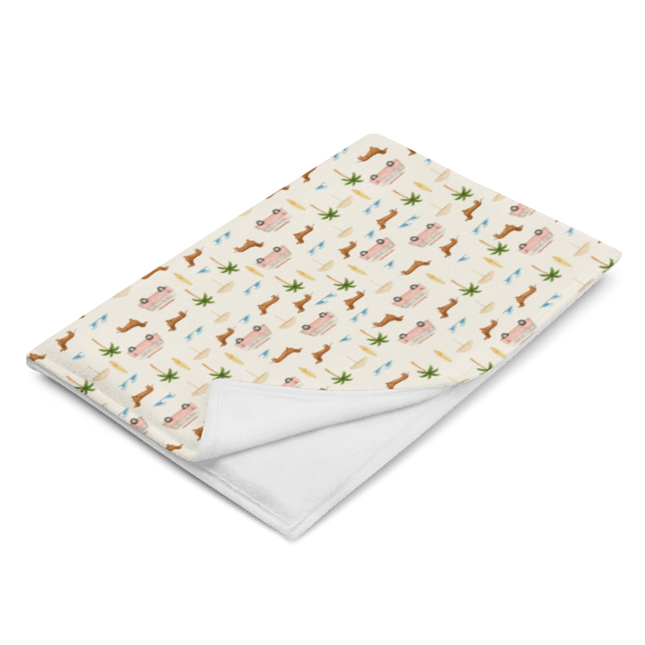 Coastal dachshund blanket draped over chair in lifestyle photo with surf van print