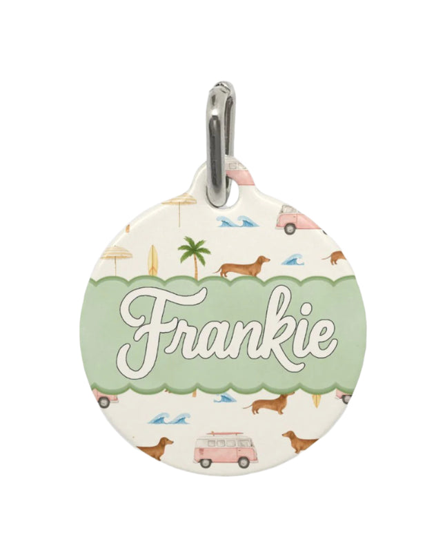 Round pet tag with 'Frankie' on a cream background featuring dachshunds, palm trees, pink vans and beach umbrellas